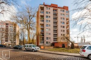 twee auto's geparkeerd voor een hoog gebouw bij Super Studio Oldtown in Gdańsk