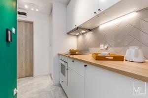 een keuken met witte kasten en een aanrechtblad bij Super Studio Oldtown in Gdańsk