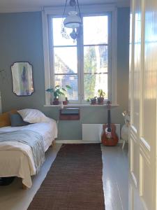 una camera con un letto e una chitarra in una finestra di Iloinen taiteilijakoti a Turku