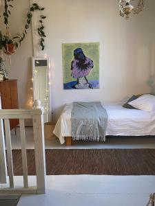 una camera da letto con un letto e un quadro sul muro di Iloinen taiteilijakoti a Turku Altre 5 foto