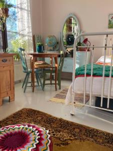 una camera da letto con un letto, un tavolo e uno specchio di Iloinen taiteilijakoti a Turku