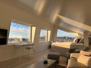 a bedroom with a bed and a couch and windows at Magical premium home in the best location in Bovallstrand
