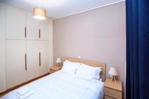 a bedroom with a large white bed with two lamps at Peaceful Renovated Apartment Near Lycabettus Hill in Athens