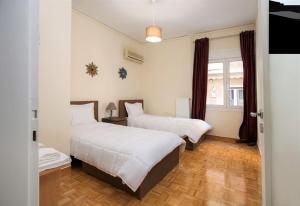 a bedroom with two beds and a window at Peaceful Renovated Apartment Near Lycabettus Hill in Athens +17 photos