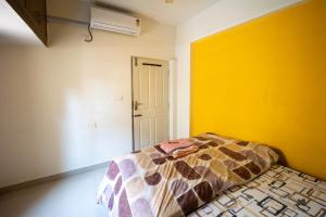 a bedroom with a bed and a yellow wall at HRBR Enclave one BHK with fully furnished in Bengaluru