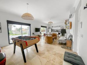 ein Wohnzimmer mit einer Tischtennisplatte in der Mitte in der Unterkunft Piscine privée proche Thalassothérapie et Mer in Pornic