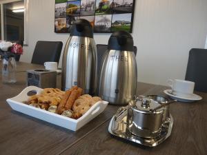 a table with two thermos and a tray of cookies at Hoeve Meerzicht in Monnickendam