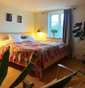 a bedroom with a bed with a colorful bedspread and a window at Townhouse by marina, beach & theatre in Ystad