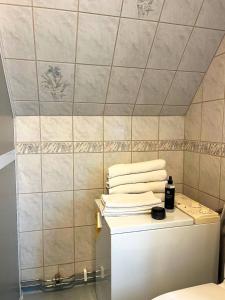a bathroom with a pile of towels on top of a toilet at Townhouse by marina, beach & theatre in Ystad