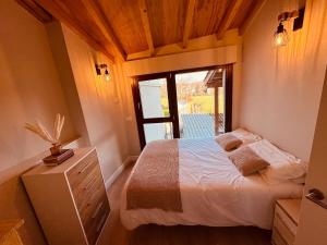 a small bedroom with a bed and a window at Casa a Xanela Azul in Celanova