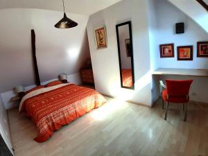 una camera da letto con un letto, una scrivania e una sedia di La Maison Douce a Saint-Guyomard