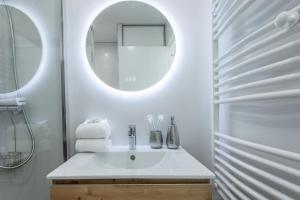 une salle de bain blanche avec un lavabo et un miroir dans l'établissement Appartement à Saint-Raphael, à Saint-Raphaël 18 autres photos