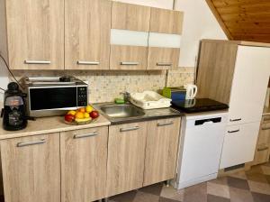 a kitchen with a sink and a microwave at GANCZ APARTMAN in Sárvár