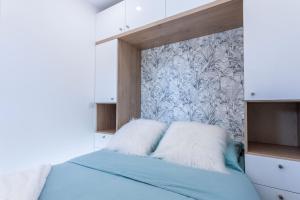 - une chambre avec un lit bleu et du papier peint dans l'établissement Appartement à Saint-Raphael, à Saint-Raphaël