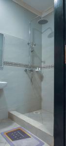 a shower with a glass door in a bathroom at Luxe City Stays by Daph in Buwate
