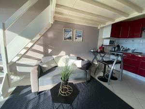 una sala de estar con un sofá y una mesa en La lumière du lac, duplex avec vue lac, parking, en Veyrier-du-Lac