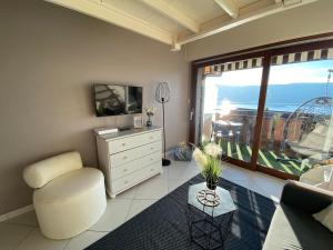 sala de estar con TV, silla y ventana en La lumière du lac, duplex avec vue lac, parking, en Veyrier-du-Lac