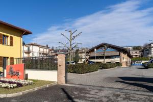 a gate in front of a building with a tree at Appartamenti "Primula - Fiordaliso" - Cascina Da Rosa in Capiago Intimiano