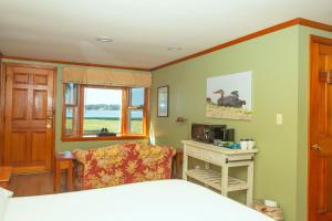 a bedroom with a bed and a desk and a window at Sandaway Suites & Beach in Oxford