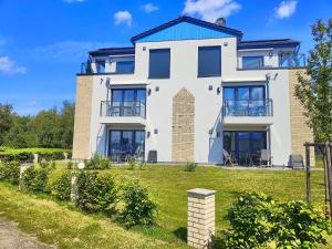 a large white house with a blue roof at Marina-Penthouse 625 in Zielow