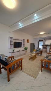 a large living room with wooden furniture and a flat screen tv at Casa Marabella in Diani Beach