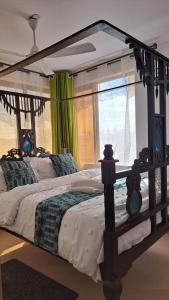 a bedroom with a large bed with a wooden frame at Casa Marabella in Diani Beach