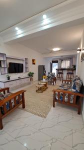 a large living room with couches and a flat screen tv at Casa Marabella in Diani Beach