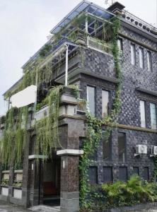 a building with ivy growing on the side of it at Residence Rafitha in Yogyakarta