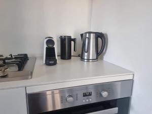 a kitchen counter with a coffee pot and a stove at Marina Tower - Stunning Harbour & City View in Melbourne