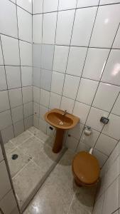 a bathroom with a sink and a toilet at Casa Peruíbe Somar in Peruíbe +8 photos