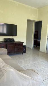 a living room with a flat screen tv on the wall at Casa Peruíbe Somar in Peruíbe