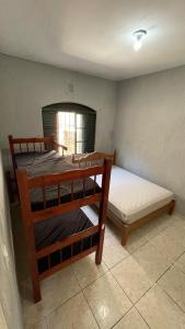 two bunk beds in a room with a window at Casa Peruíbe Somar in Peruíbe