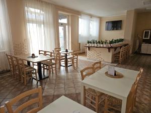 a dining room with tables and chairs and windows at Hotel Prim in Bratislava