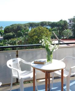 una mesa con un jarrón de flores en el balcón en Tizi Apartments en Maiori