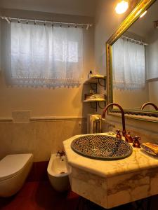 a bathroom with a sink and a toilet and a mirror at La Gemma del Subasio nel Castello di Collepino - Spello in Collepino +128 photos