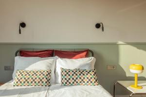 a white bed with two pillows and a shelf above it at Cozy Apartment with Balcony near Old Town Gdańsk by Rent like home in Gdańsk