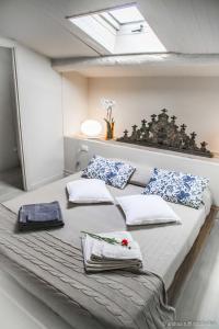 uma cama grande com almofadas num quarto em Il rifugio degli Innamorati...di Lucca em Lucca