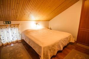 ブオカッティにあるVuokatti Apartmentsの木製の天井のベッドルーム1室(ベッド1台付)