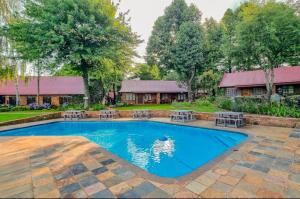 a swimming pool with chairs and a house at Lakeside 12 in Dullstroom