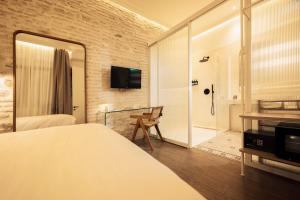 a hotel room with a bed and a walk in shower at Hotel Boutique Escudo del Carmen in Granada +75 photos