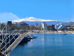 a marina with a snow covered mountain in the background at Studio 49 - da Frank in Giardini Naxos