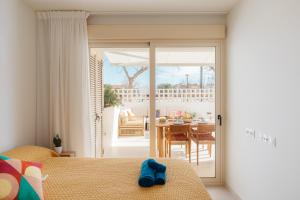 Un dormitorio con una puerta abierta a un patio con una mesa. en Terrasses - Beach apartment with swimming pool, en Puzol