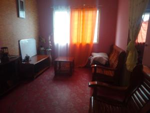 a living room with chairs and a television and a window at Homestay Ria in Kuala Lumpur