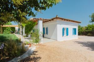 a small white house with blue shutters at Spacious House with Cottage&Pool in Nafplio
