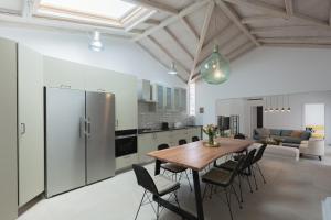 a kitchen and dining room with a wooden table and chairs at Spacious House with Cottage&Pool in Nafplio