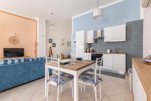 Una cocina y una sala de estar con mesa y sillas. en Open Space a 1' dalla Stazione, en La Spezia