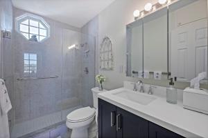 a white bathroom with a sink and a toilet at Coastal waterfront condo located in Olde Marco in Marco Island +39 photos