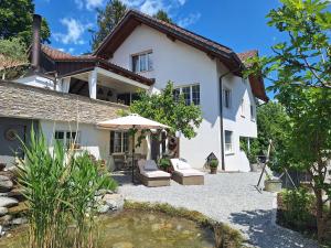 a house with an umbrella and a patio at Filipponi's Träumli in Rüthi