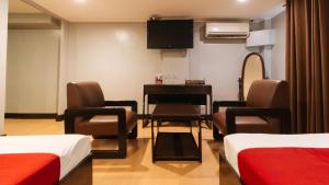 a room with two beds and a table and a television at RedDoorz at Homa Resort Hotel in Camotes Islands