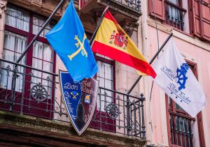 three flags on the side of a building at Don Pedro in Avilés